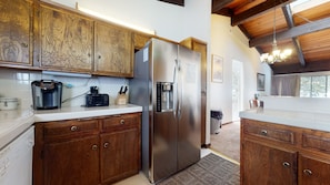 Enjoy cooking in this well-equipped kitchen with a refrigerator, coffee maker, and knife block.