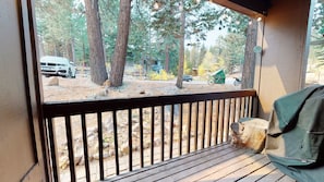 Enjoy the serene forest views from this deck with a bench and railing.
