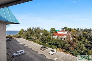 Enjoy a peaceful residential setting with a spacious parking lot and lush greenery.