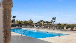A swimming pool with lounge chairs and a palm tree. - Tybee Beach views, just steps to the ocean (Tybee Island)