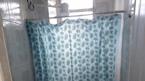 A small, basic bathroom with a toilet, a roll of toilet paper, and a shower curtain. - Ps Hotel Manilha (Itaborai)