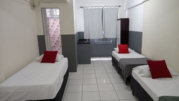 A hotel room with two single beds, a small kitchenette, and a shower area. - Ps Hotel Manilha (Itaborai)