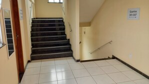 A staircase leading to a landing with a sign indicating room numbers 301-307. - Ps Hotel Manilha (Itaborai)