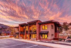 A modern two-story building with a brick facade, large windows, and a covered outdoor area.