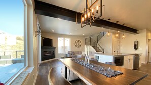 A modern kitchen with a central island, built-in appliances, and a large window overlooking a deck. - New Family-Friendly Home Overlooking Fox Creek, Large Deck & Cozy Furnishings (Steamboat Springs)