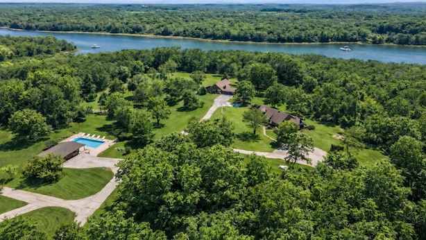 Vista aérea de una zona residencial con piscina, varias casas y un lago.