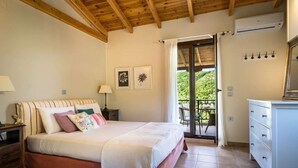 A bedroom with a bed, bedside tables, a dresser, and a view of the outdoors. - Luxurious Pool Villa Kavalos (6-11people) (Kavallos)