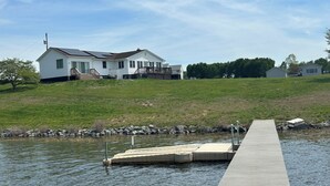 A house with a dock extending into a body of water. - Whippoorwill Cottage - Dock, Fire Pit, Boat Launch, Spectacular Views (Mineral)