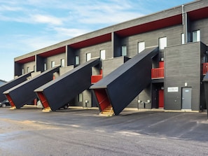 A modern building with multiple balconies and a flat roof.