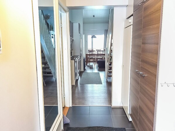 Ein Flur mit Treppe, Essbereich und Holztür.