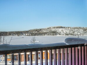 A snow-covered landscape with a view of a building with a balcony.