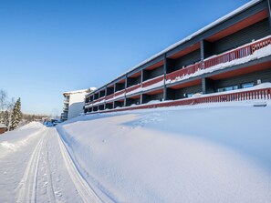 A multi-story building with balconies, surrounded by snow-covered terrain. - Skivillas 61 ukkohalla (b1) by Interhome (Hyrynsalmi)