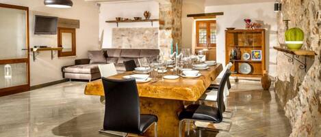 A spacious dining area with a long wooden table set for six, surrounded by modern chairs.