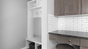 A kitchen with white cabinetry, a tiled backsplash, and a countertop with a sink. - Grey Havens Laneway home w/ garage, balcony, AC near WEM! (Edmonton)