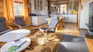 A cozy cabin interior with a dining area, kitchen, and seating space.