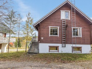 A two-story wooden house with a visible staircase and a ladder.