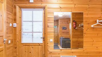 Un intérieur en bois avec une porte, un miroir, un radiateur et un extincteur.