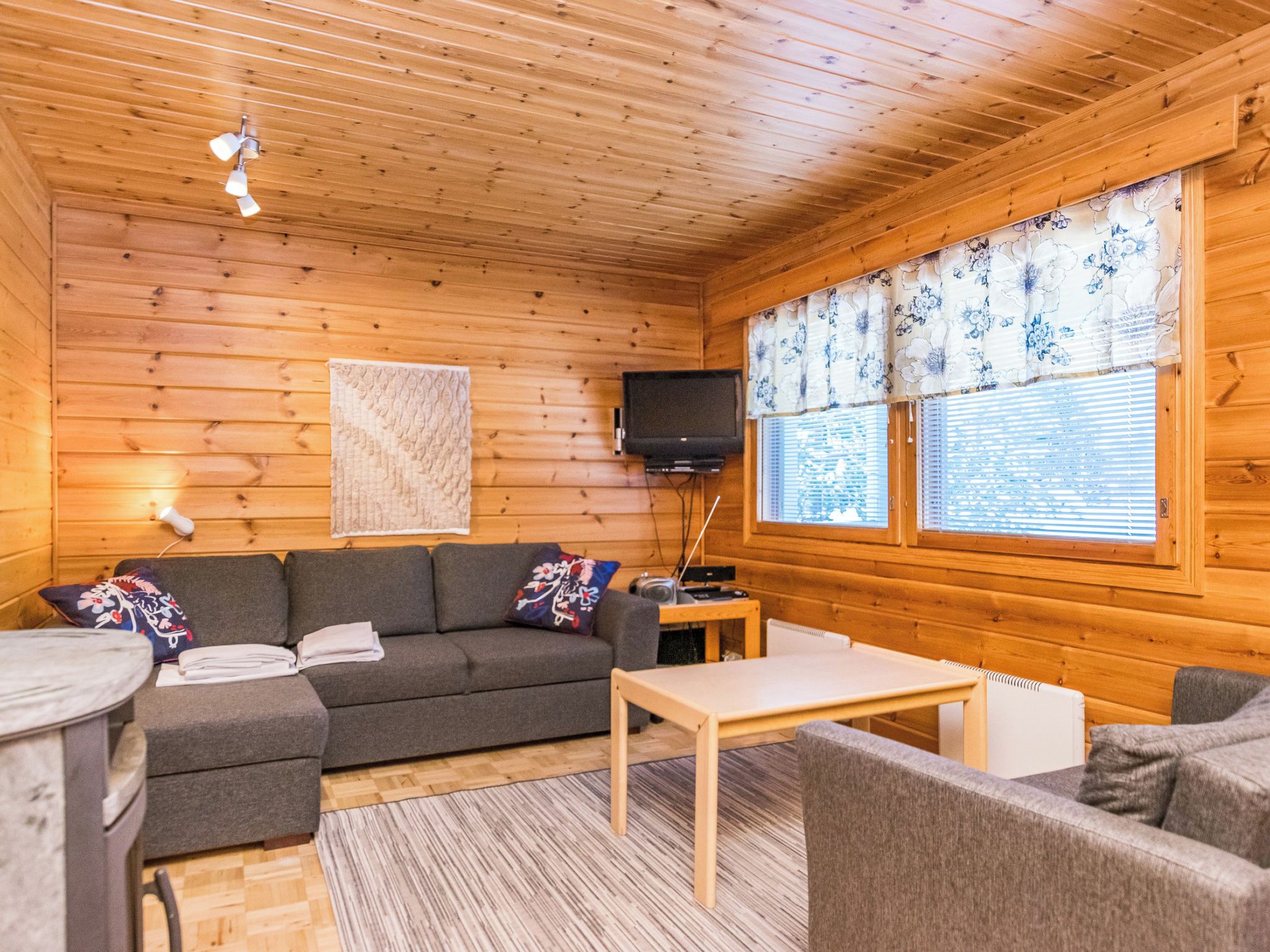 L’intérieur d’un chalet confortable, avec un canapé, une petite table et un téléviseur.