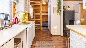 A compact kitchen with wooden beams, a built-in bench, and a small dining area. - Kulma-alpit a by Interhome (Hyrynsalmi)