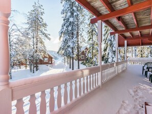 A snow-covered outdoor area with a wooden pergola and a white balustrade. - Kulma-alpit a by Interhome (Hyrynsalmi)