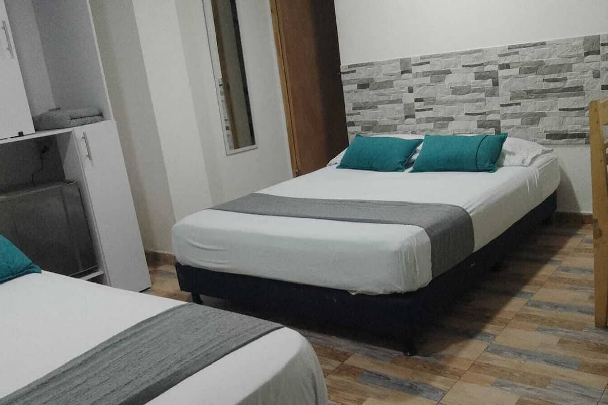 Ein Schlafzimmer mit zwei Betten, einem Kleiderschrank und einem kleinen Schreibtisch.
