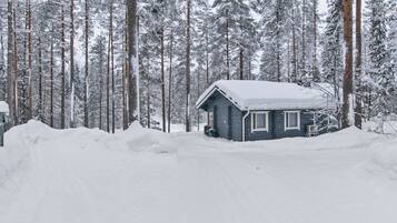 Une cabane entourée d’arbres couverts de neige.