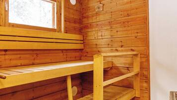 A wooden cabin interior with a bench, a shelf, and a window.