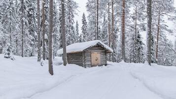 Una baita coperta di neve in una foresta.