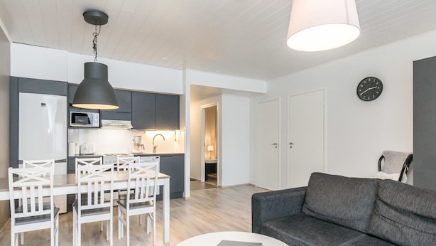 A modern apartment with a dining area, kitchen, and living room.