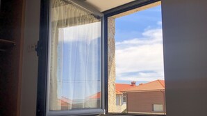 A room with a window overlooking a residential area. - Casa d’El Rey, Serra da Freita/Passadiços do Paiva (Mizarela)