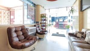 Een modern interieur met leren banken, een glazen scheiding en uitzicht op de straat.