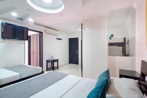 A modern hotel room with a large bed, a TV mounted on the wall, a small table, and a wardrobe. - Hotel Ayenda Castillo Real 1521 (Bucaramanga)