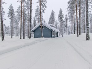 Escape to a serene cabin nestled among snow-covered pine trees, perfect for a peaceful retreat in nature.