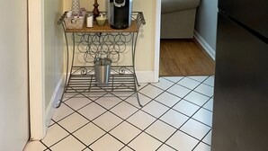 Cozinha com cafeteira, um letreiro indicando 'Café Fresco' e uma guirlanda decorativa.