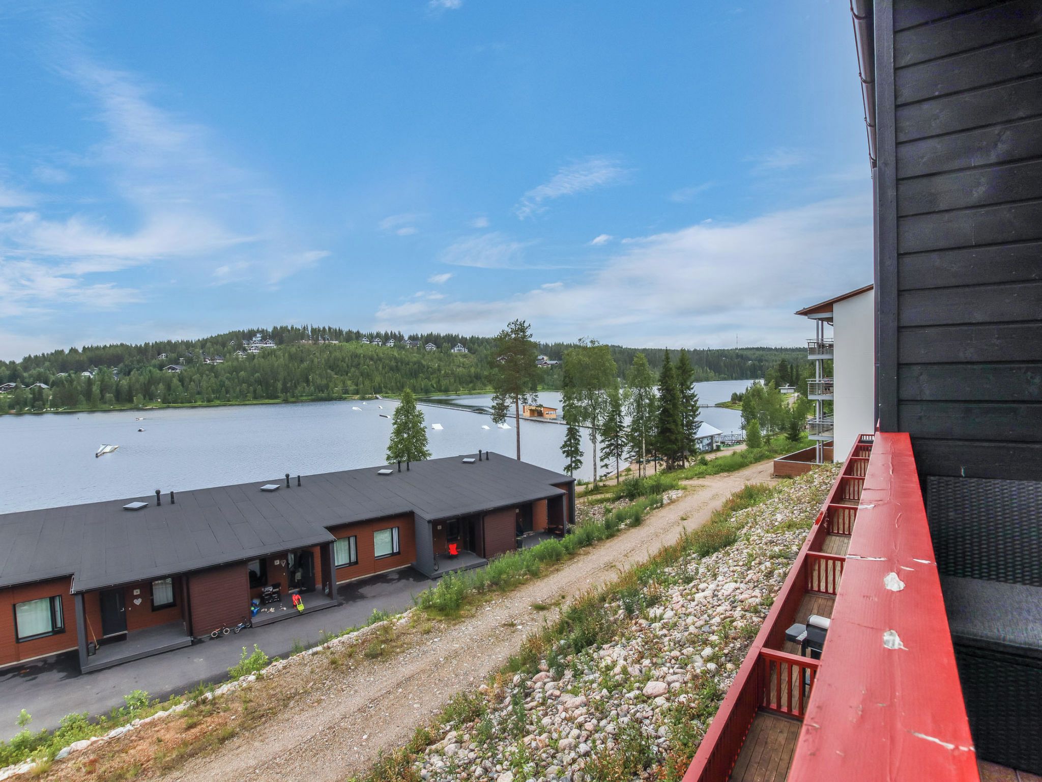 A lakeside hotel with a view of the lake and forested hills.