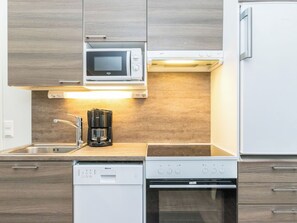 Eine moderne Küche mit integriertem Mikrowellenherd, Kaffeemaschine, Geschirrspüler und Backofen.
