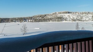 A snowy landscape with a clear sky, a snow-covered hill with buildings, and a flat snowfield. - Skivillas 61 ukkohalla (b3) by Interhome (Hyrynsalmi)