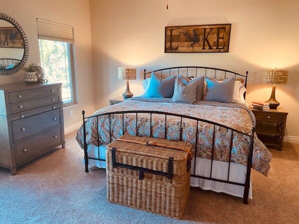 A bedroom with a bed, two bedside tables, a dresser, a mirror, and a wall with a 'LIKE' sign. - Porto Cima Lakefront Home in calm water cove perfect for Family Fun! (Sunrise Beach)