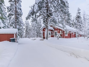 Et rødt hus omgivet af sneklædte træer.