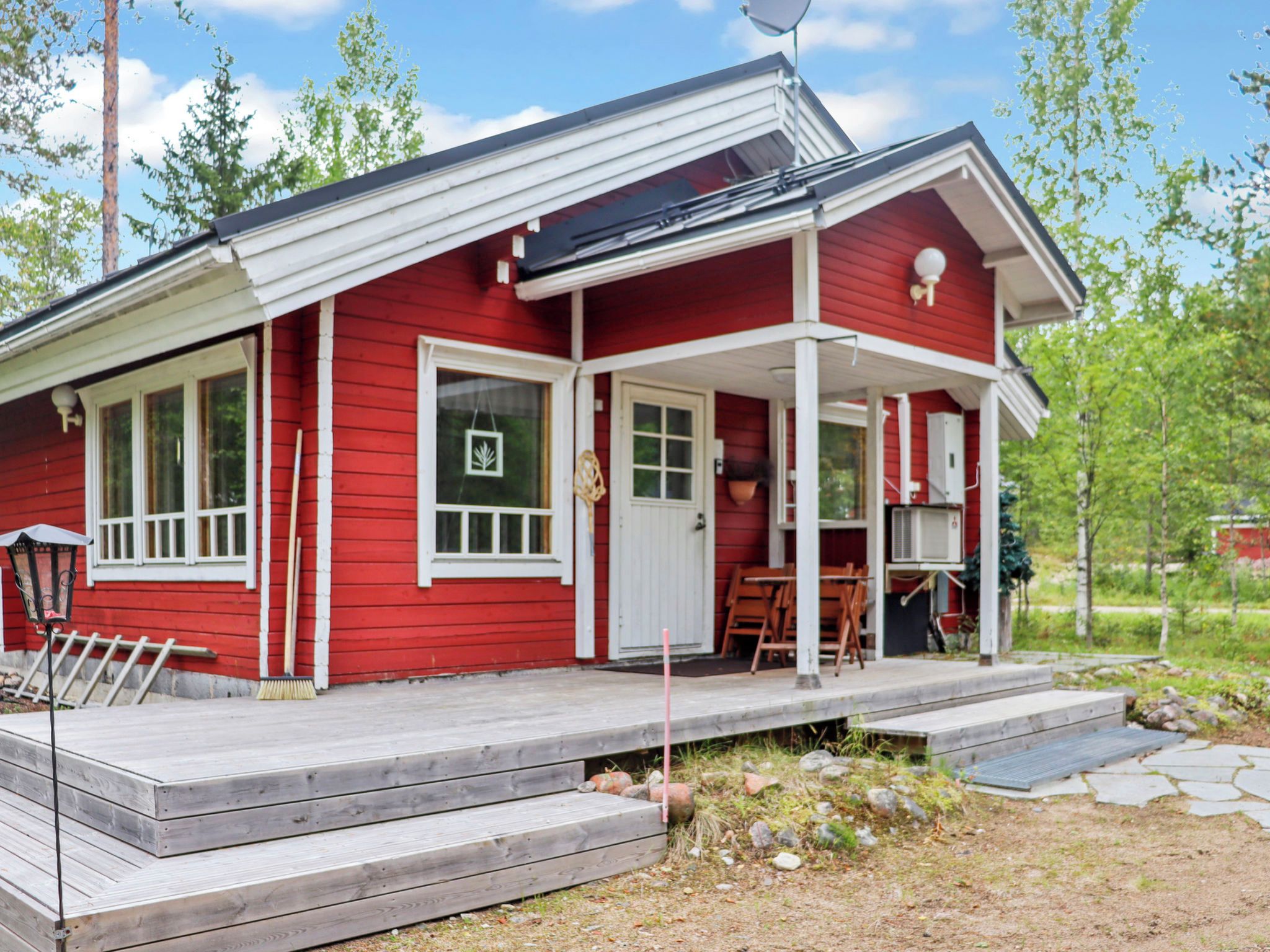 A red house with a porch, a door, and a window.