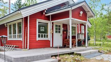 A red house with a porch, a door, and a window.