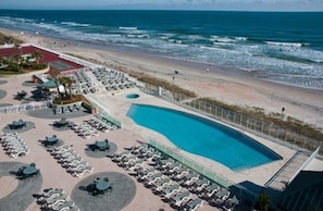 Ein Resort mit großem Pool, Zugang zum Strand und Außenbereichs-Sitzgelegenheiten.