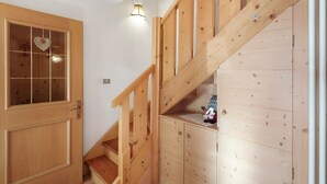 A wooden staircase with a glass door and a small shelf with a toy. - Holiday Apartment "Ciasa Lino Rotic" with Mountain View and Wi-Fi (San Giovanni di Fassa)