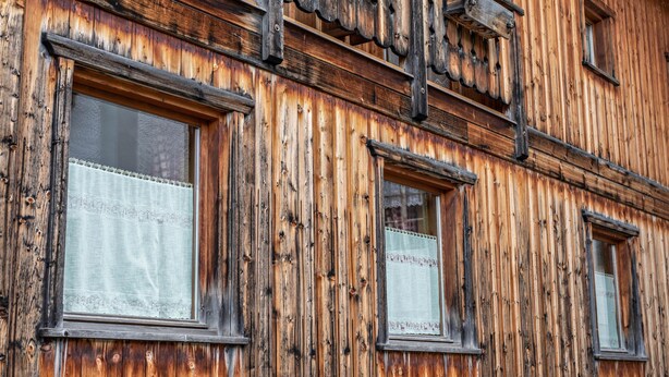 Un edificio de madera con varias ventanas y un balcón.