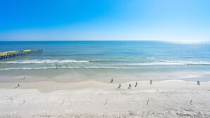 A beach with a pier extending into the ocean, sandy beach, and calm sea. - Oceanfront-EV Charging-Aruba #704 (Daytona Beach Shores)