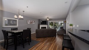 A modern living room with a dining area, a fireplace, and a bar. - Parkview Bay 212 - Lakeside Condo w/State Park View (Osage Beach)