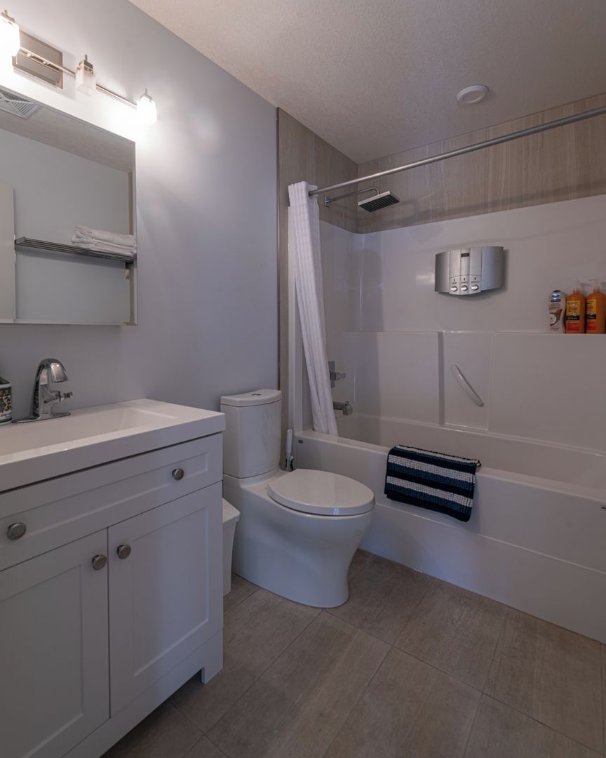 Een moderne badkamer met toilet, wastafel en douche.