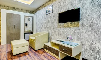 Una habitación con armario, sofá, televisor y un mueble pequeño.