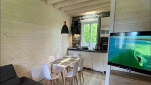 Um espaço compacto com área de refeições, sofá, televisão e cozinha.
