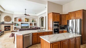 A spacious kitchen with wooden cabinets, stainless steel appliances, and a central island. - Dreamy Desert Oasis with Game Room, Heated* Pool! (Scottsdale)